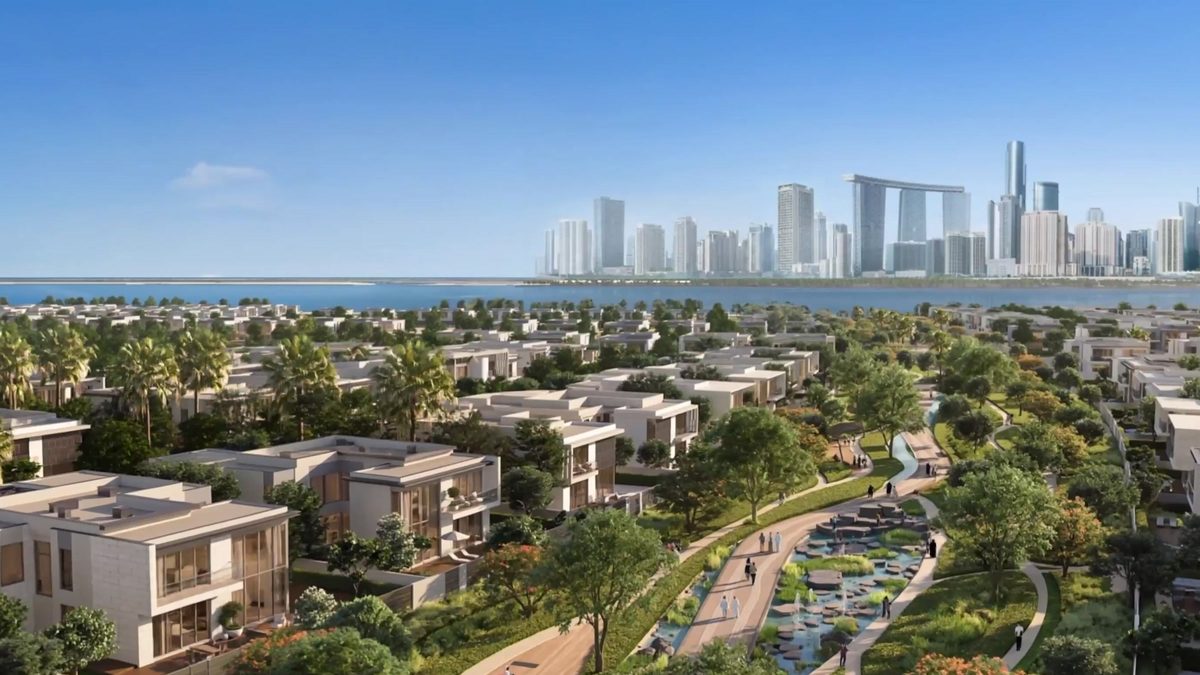 Garden villas and a green corridor from above, the city skyline on the horizon