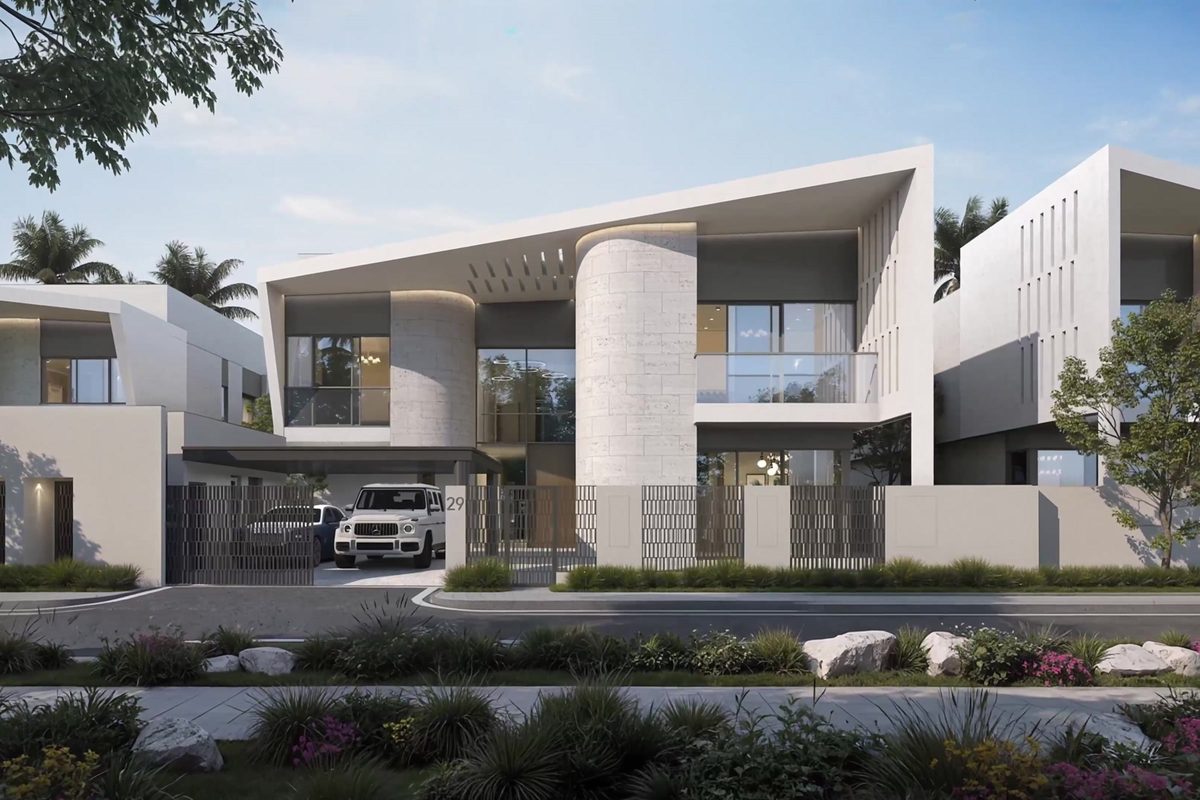Une villa de pierre claire aux toitures en porte-à-faux derrière un portail, une bande plantée le long de la rue